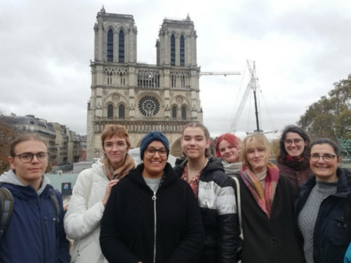 Man sieht eine Gruppe von Studierenden vor der Kathedrale Notre-Dame de Paris. 