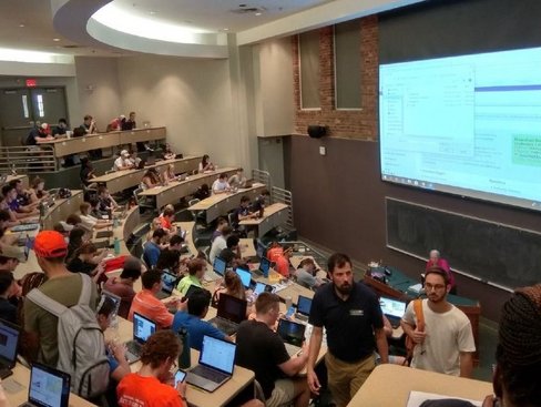 Man sieht einen Hörsaal mit vielen Studierenden an ihren Computern.