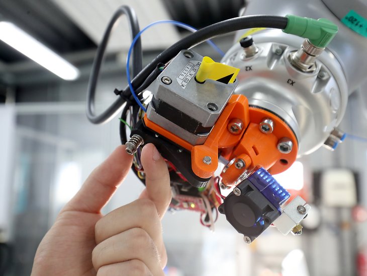 One hand operates an industrial robot.
