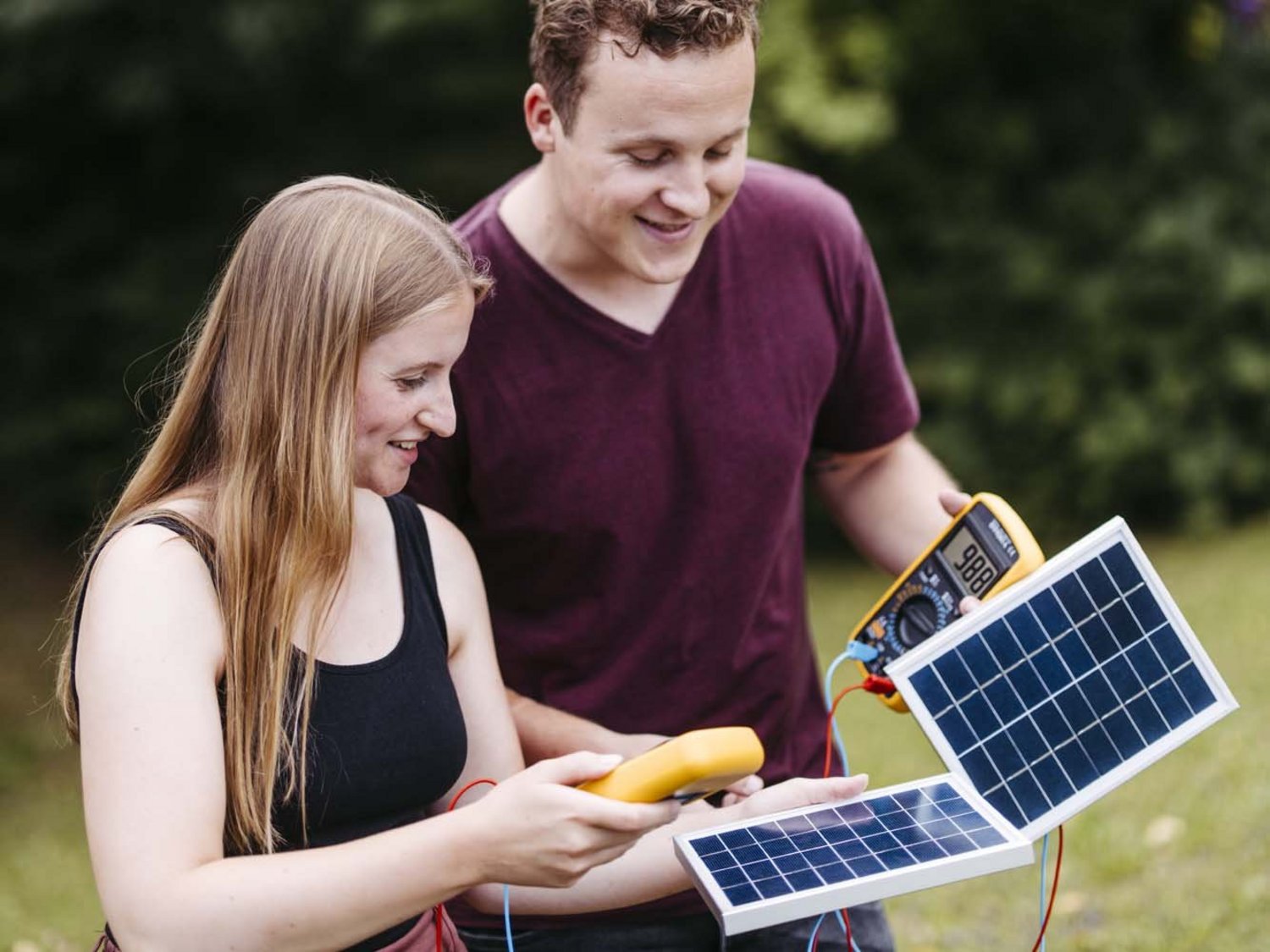 Zwei Personen sind zu sehen, sie halten sowohl ein Solarstrommesser als auch eine Solarscheibe in der Hand.