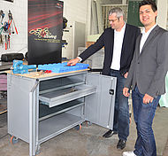 Zusammen mit dem Leiter des Kompetenzzentrums für Produktion und Logistik Landshut (PuLL), Prof. Dr. Markus Schneider, nimmt der Vorsitzende des LA eRacing e.V. Ralf Thurner die neue Werkstattausrüstung entgegen.