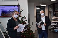 Die neue Projektbroschüre präsentiert vor dem Weihnachtsbaum