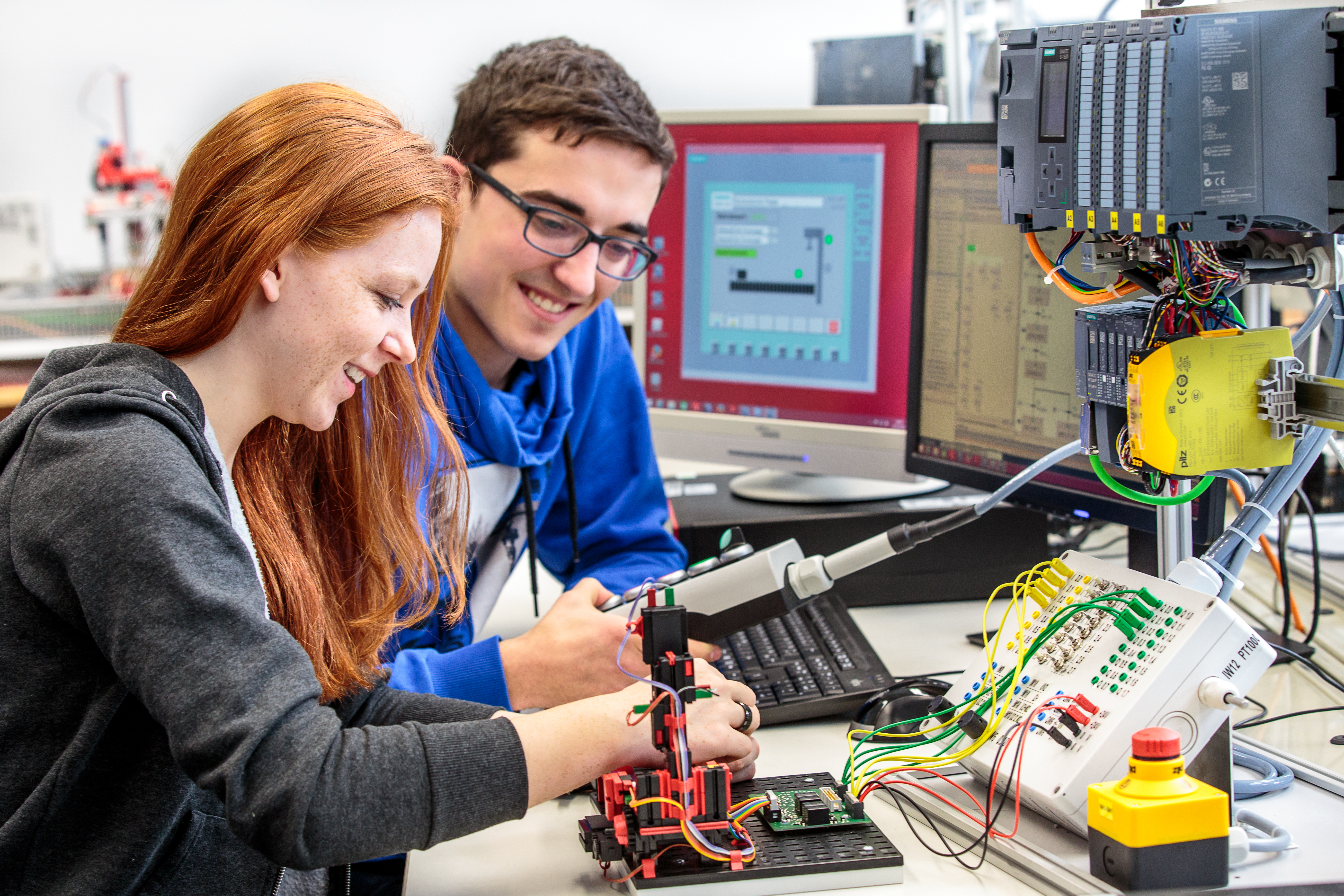 Zwei Studierende arbeiten an einem Versuchsaufbau zur Steuerungstechnik.