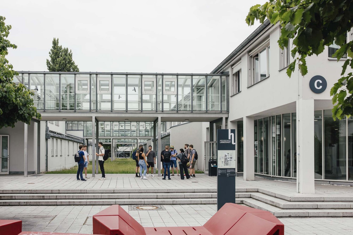 Man sieht einen Teil des Außenbereichs des Campus, im Hintergrund sieht man ein teil des C Gebäudes