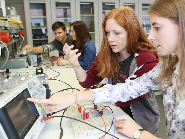 Zwei Studierende bedienen einen Versuchsaufbau mit Steckbrett.