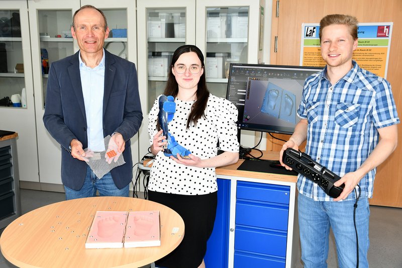 Prof. Dr. Raimund Kreis, Jasmin Franziska Steinherr und Lutz Prager (v.l.n.r.) mit Fußabdrücken in Formschaum