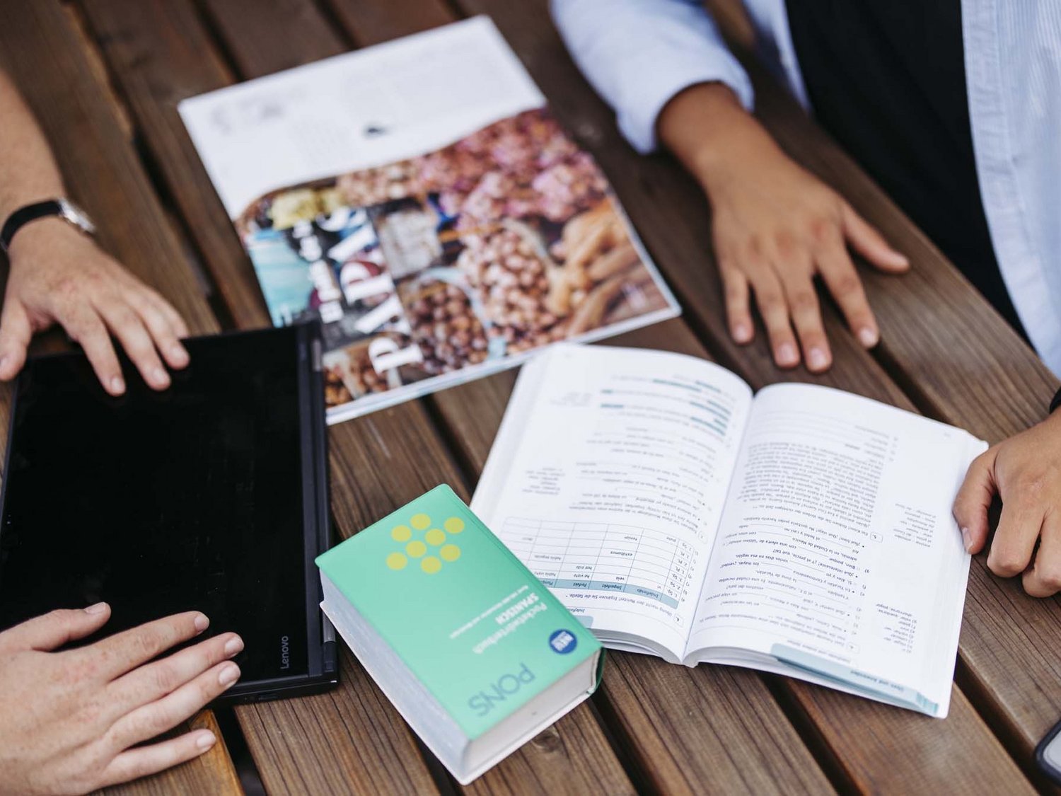 Man sieht Hefte und Bücher auf einen Tisch verteilt.