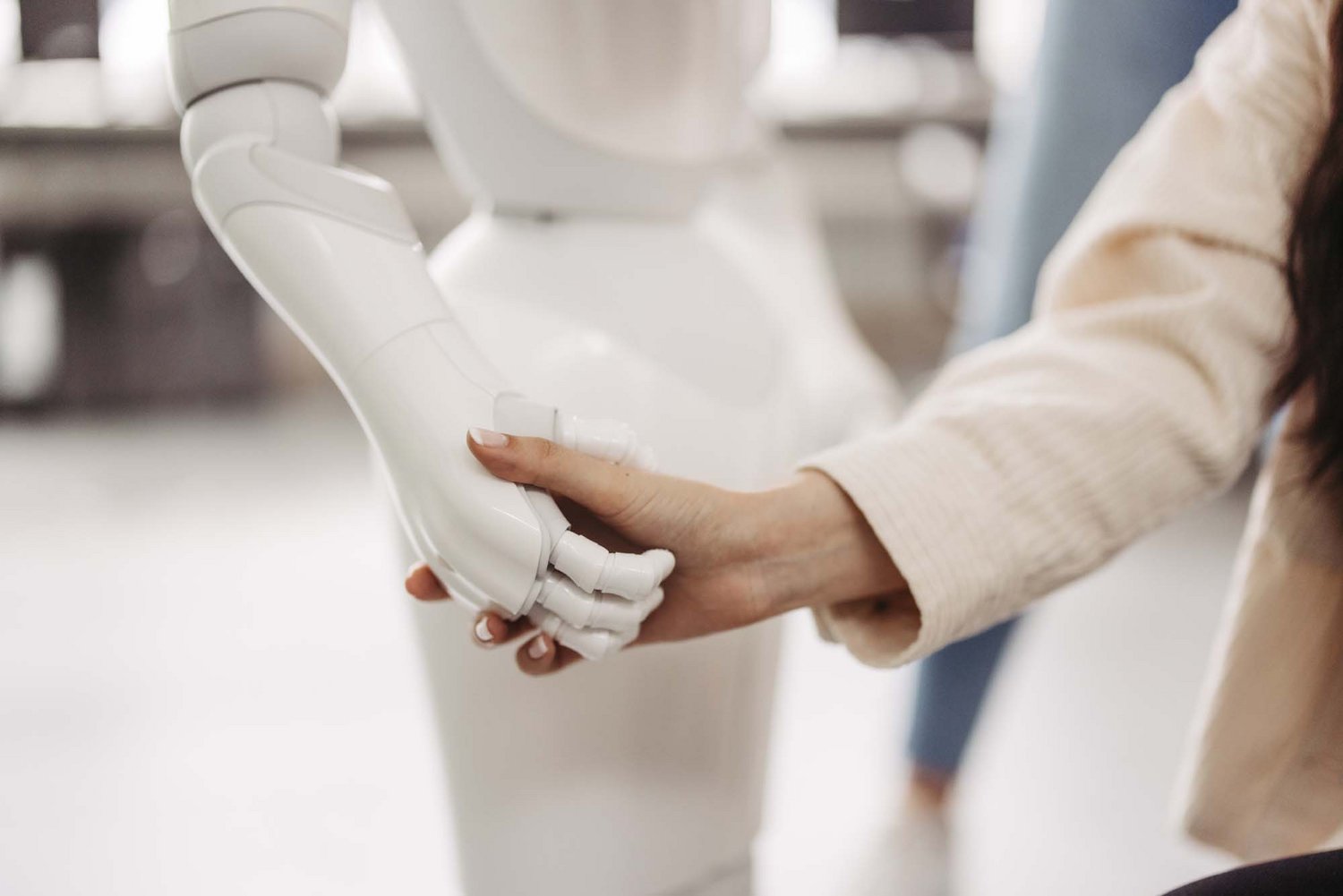 Man sieht eine Roboterhand, die die Hand einer Person hält.