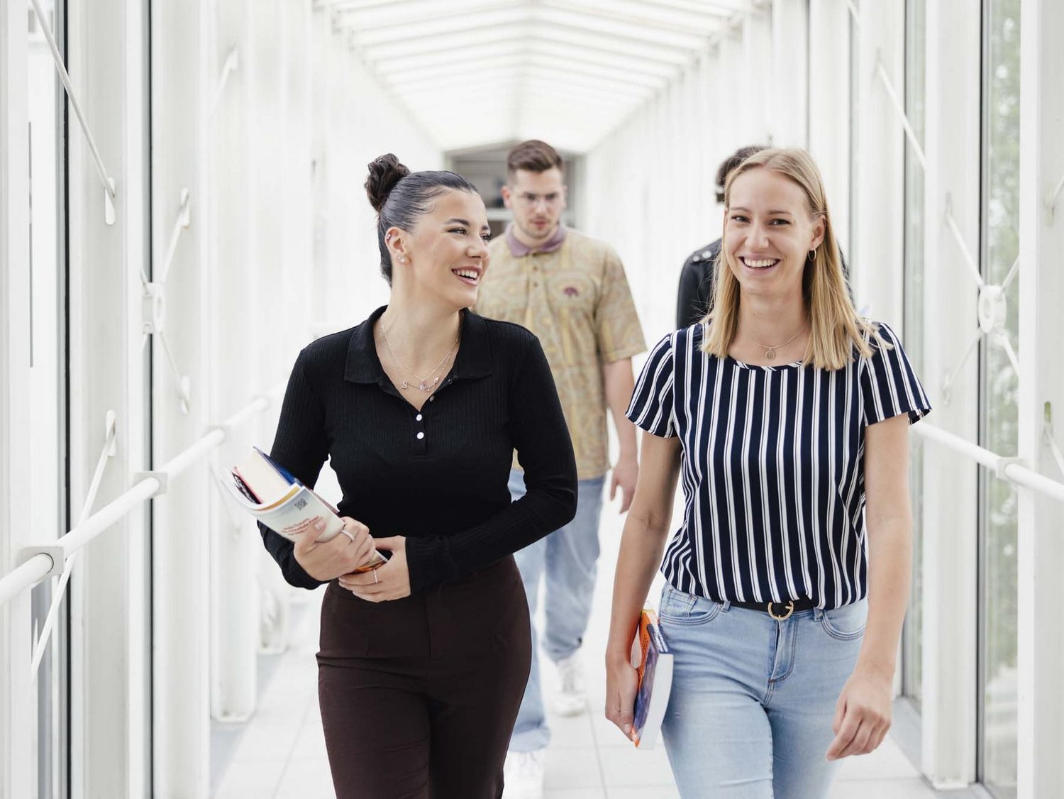 Zwei Personen gehen nebeneinander und lächeln.