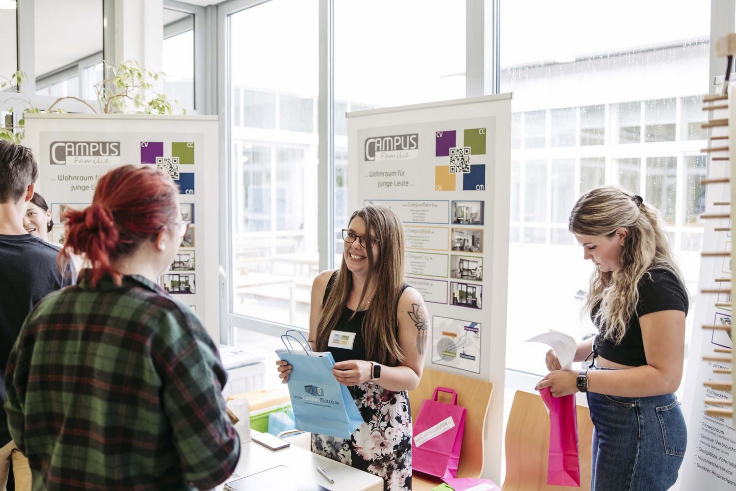 Mitglieder der Campus Familie übergeben eine Tüte