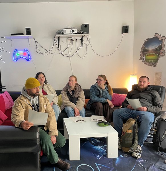 Studierende sitzen in einer Einrichtung der Mobilien Jugendarbeit auf einer Couch.