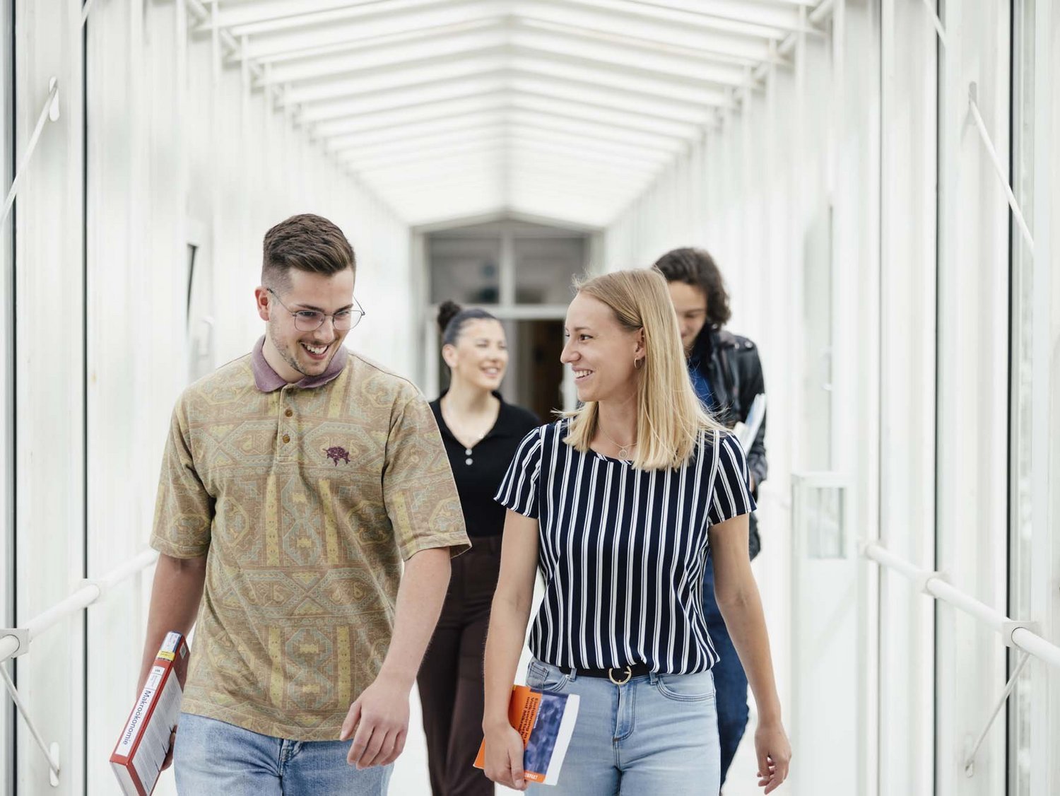 Zwei Personen gehen nebeneinander und lächeln.