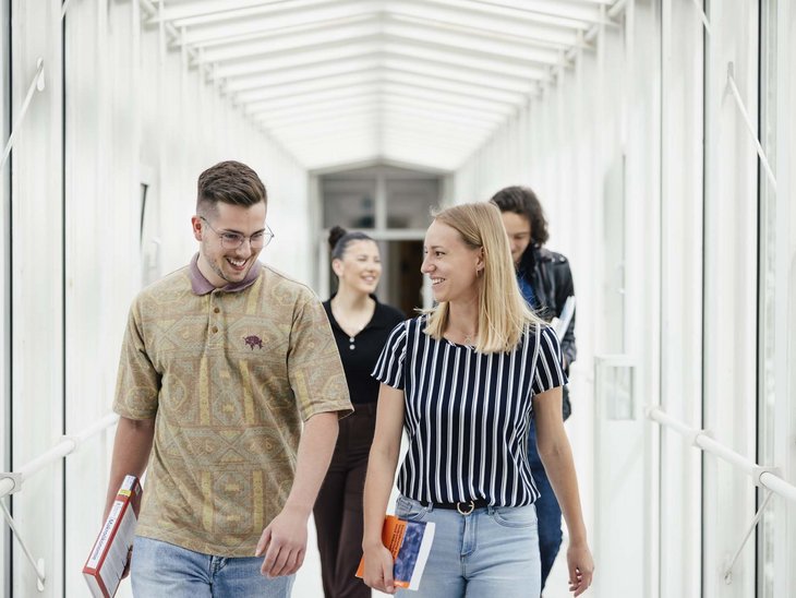 Zwei Personen gehen nebeneinander und lächeln.