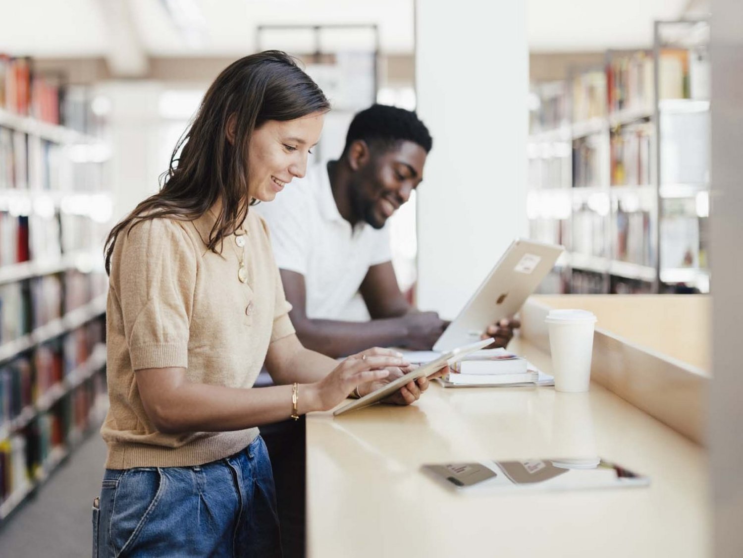 Zwei Personen lernen an einem Stehplatz von der Bibliothek