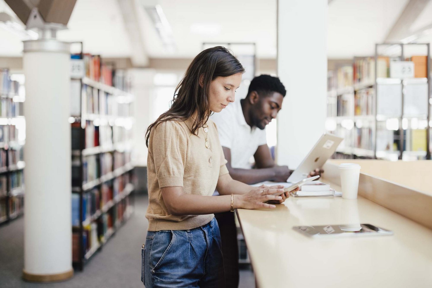 Zwei Personen lernen an einem Stehplatz von der Bibliothek