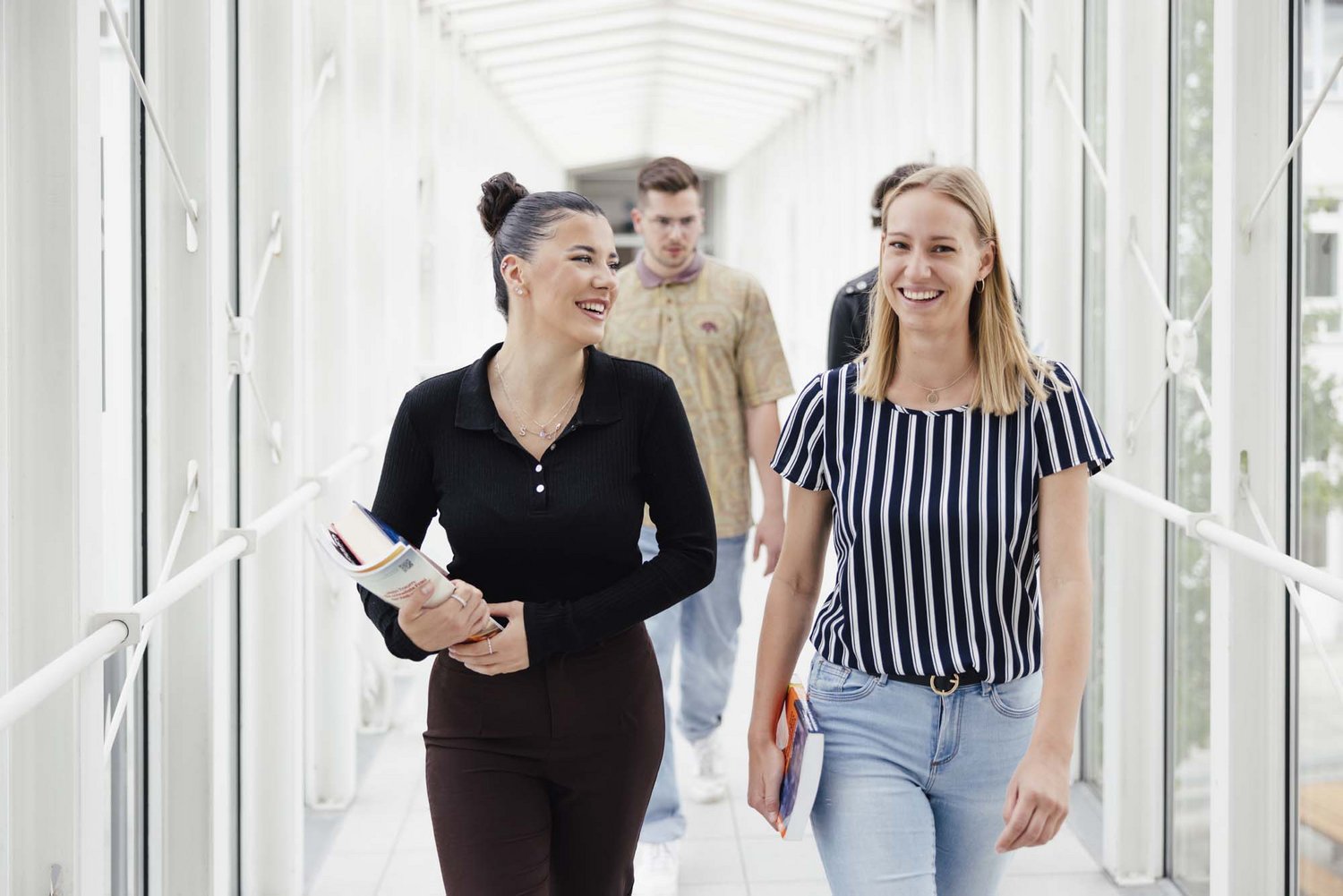 Zwei Personen gehen nebeneinander und lächeln.