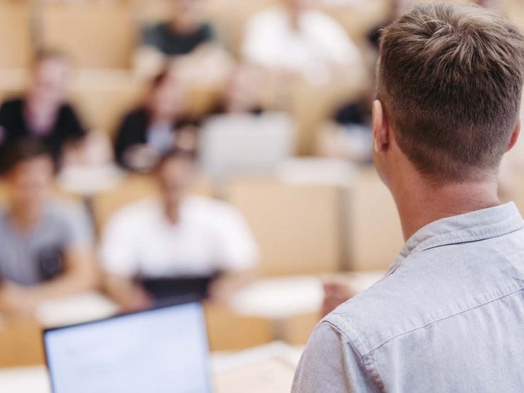Professor in a lecture theatre with students