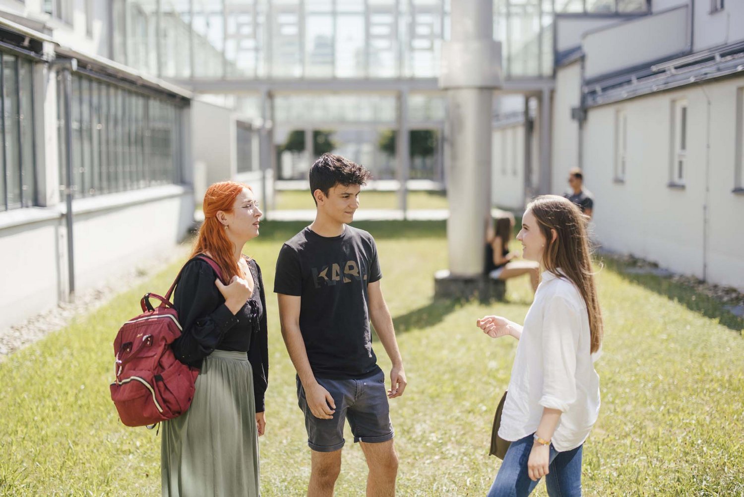 Studierende unterhalten sich draußen