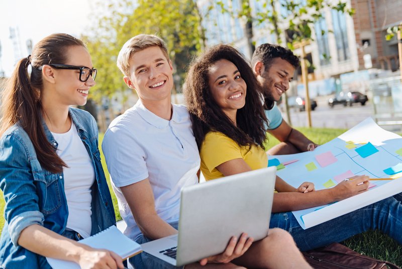 Studierende sitzen in einer Wiese