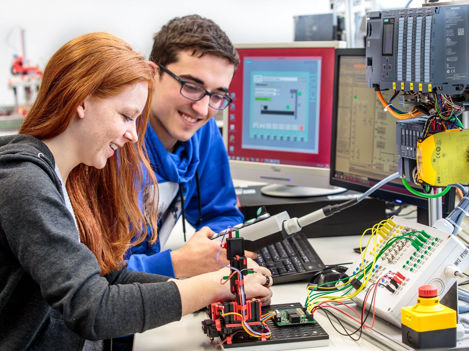 Zwei Studierende arbeiten an einem Versuchsaufbau zur Steuerungstechnik.