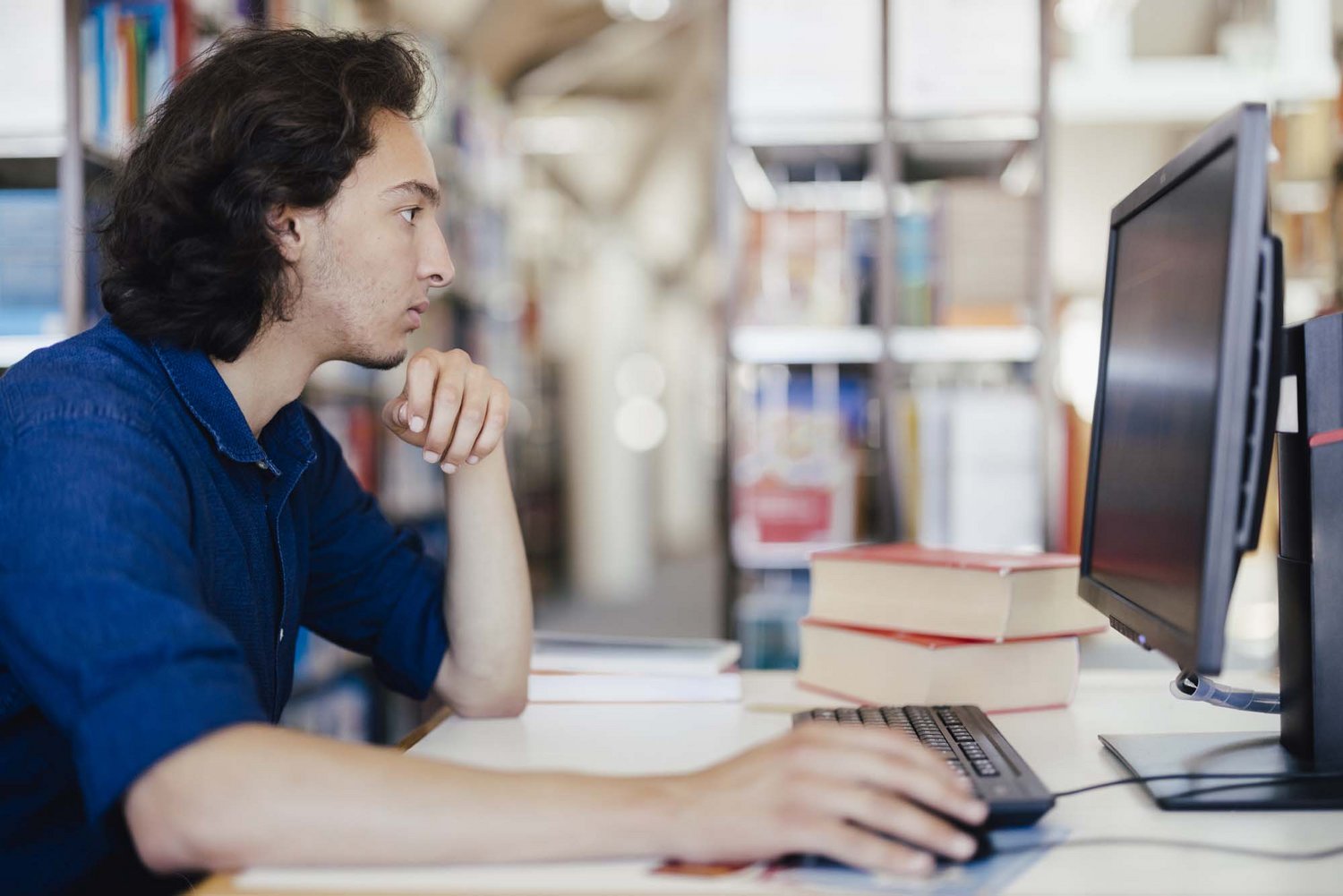 Eine Person sitzt vor einem Computer.