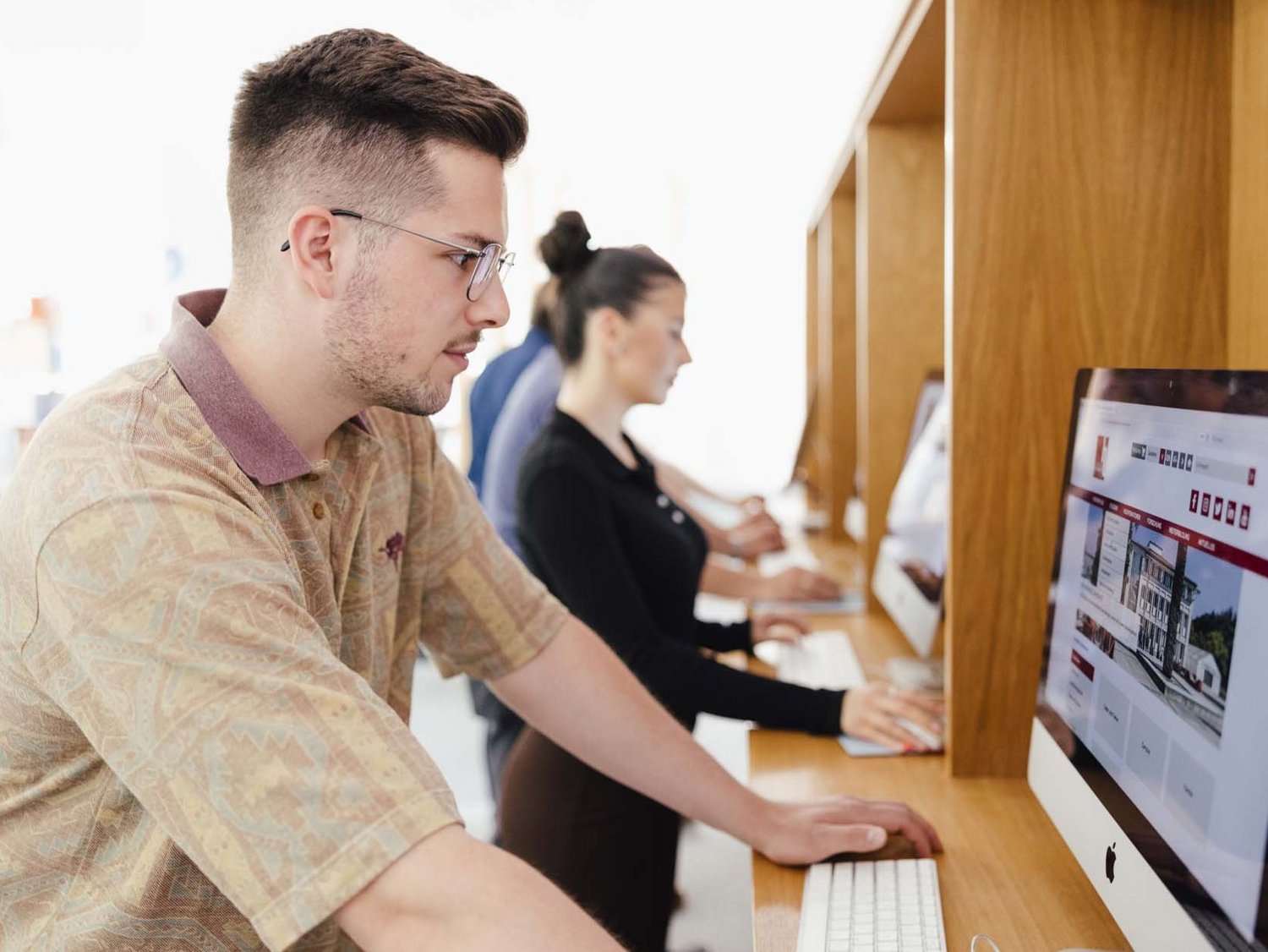 Eine Person steht an einem Computer.