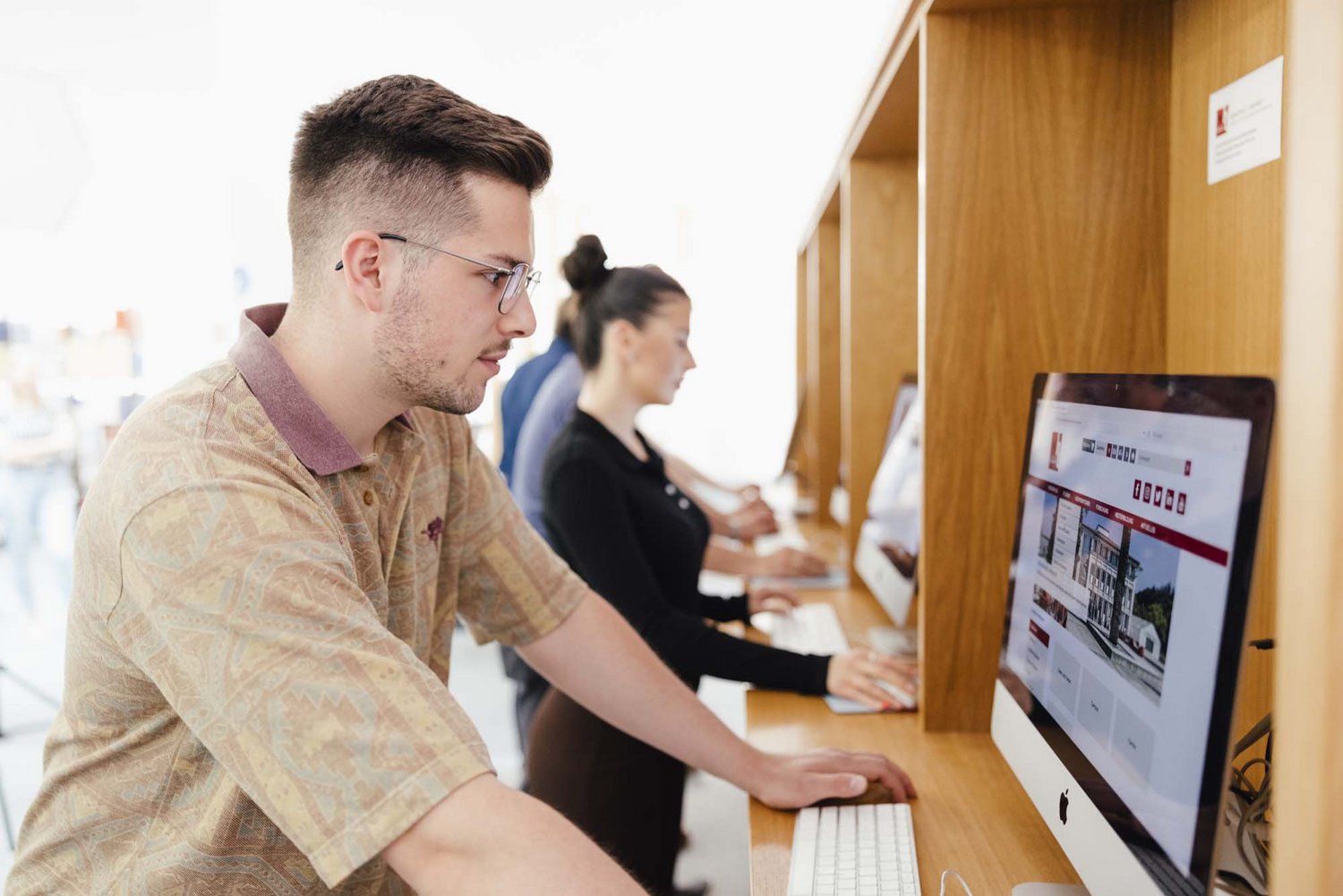 Eine Person steht an einem Computer.