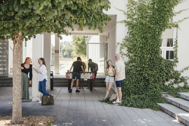 Gruppen von Studierenden, die sich unterhalten oder Kickern