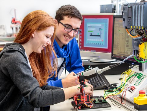 Zwei Studierende arbeiten an einem Versuchsaufbau zur Steuerungstechnik.