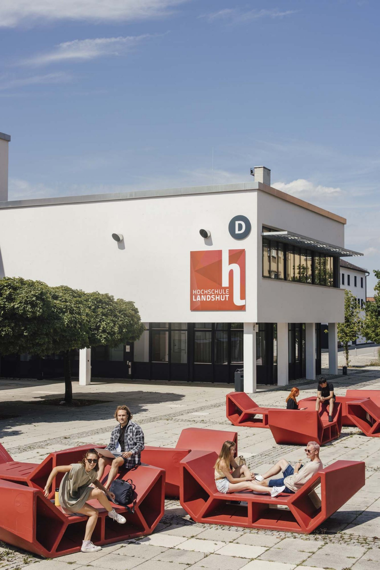 Blick auf der D-Gebäude mit studierenden sitzend auf den Enzos