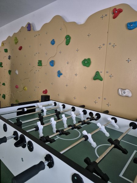 Ein Kickerkasten steht vor einer Kletterwand