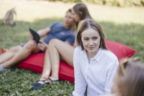 Studierende sitzen im freien und unterhalten sich