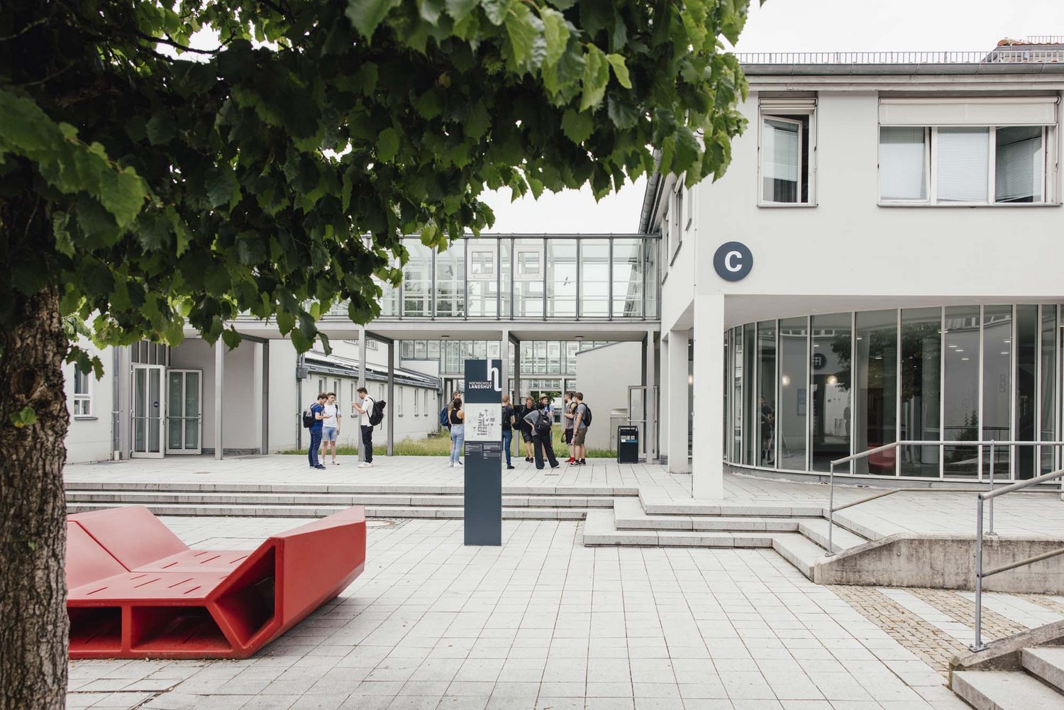 Man sieht einen Teil des Außenbereichs des Campus, im Hintergrund sieht man ein teil des C Gebäudes