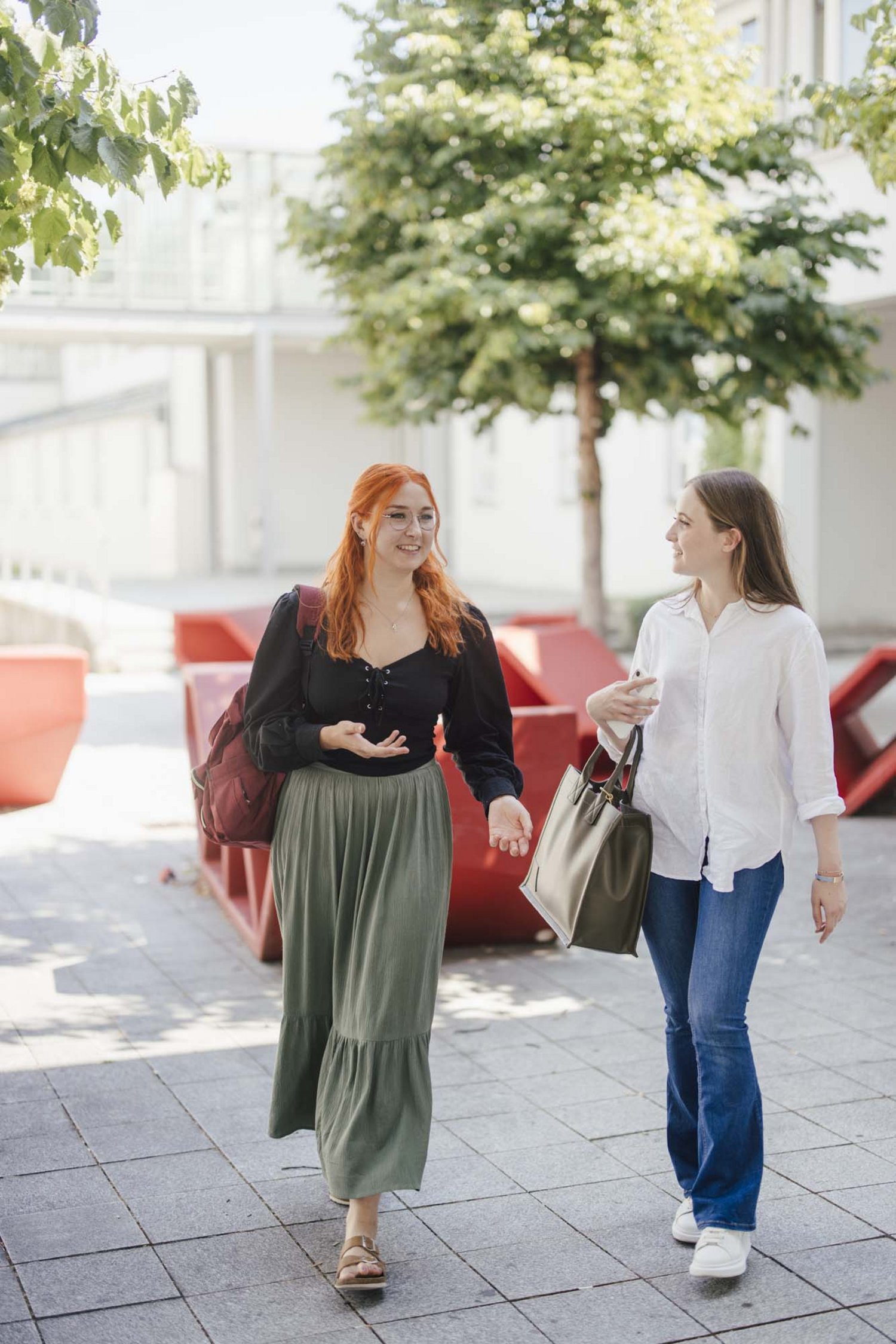 Zwei Studierende unterhalten sich beim gehen