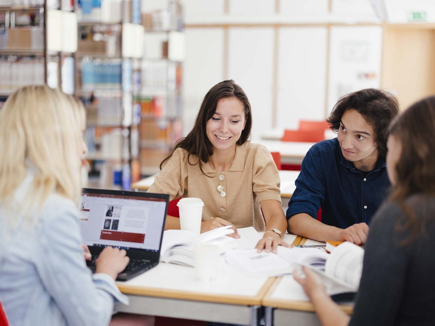 Eine Gruppe sitzt am Tisch und arbeitet zusammen