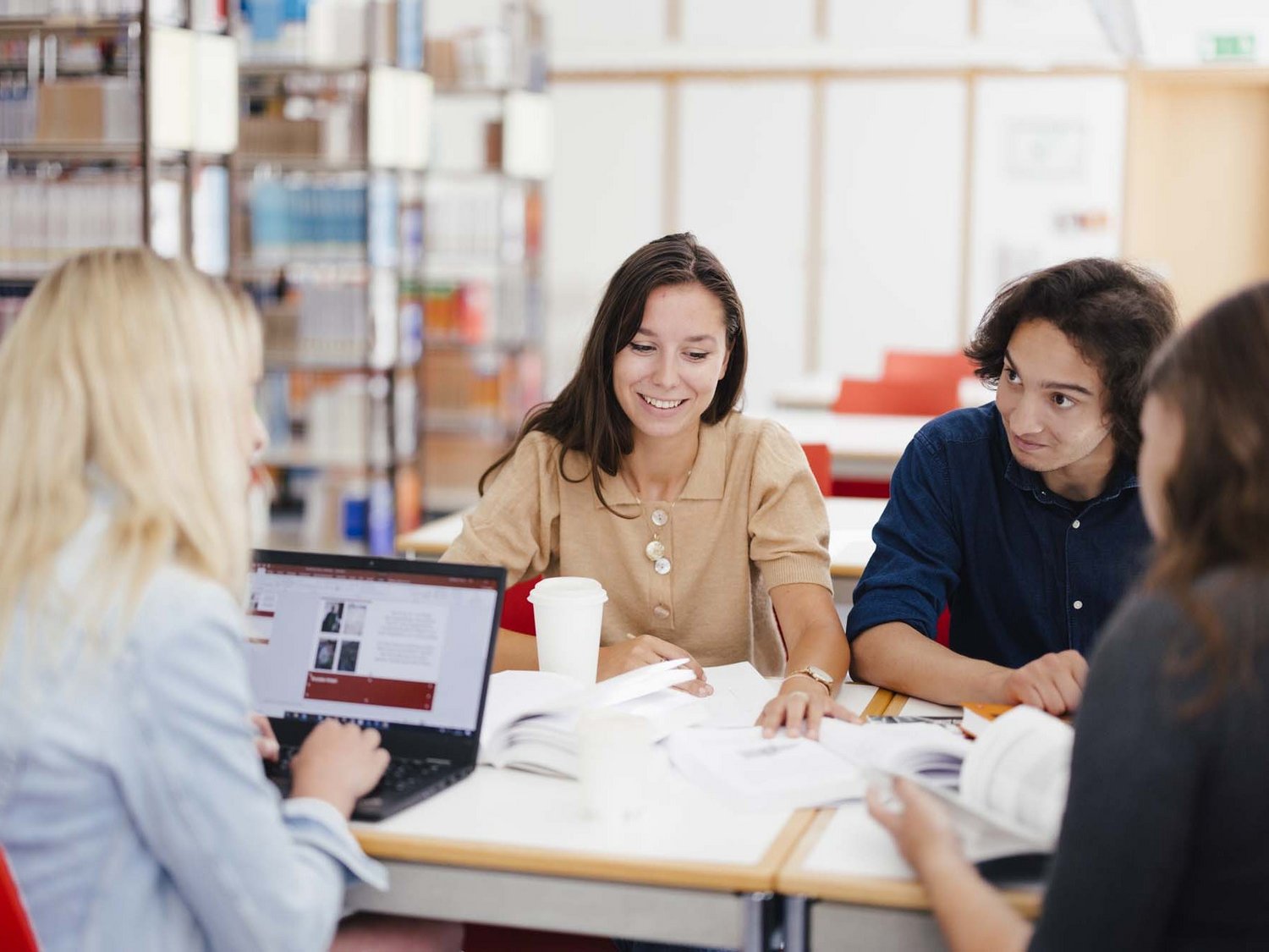 Eine Gruppe sitzt am Tisch und arbeitet zusammen