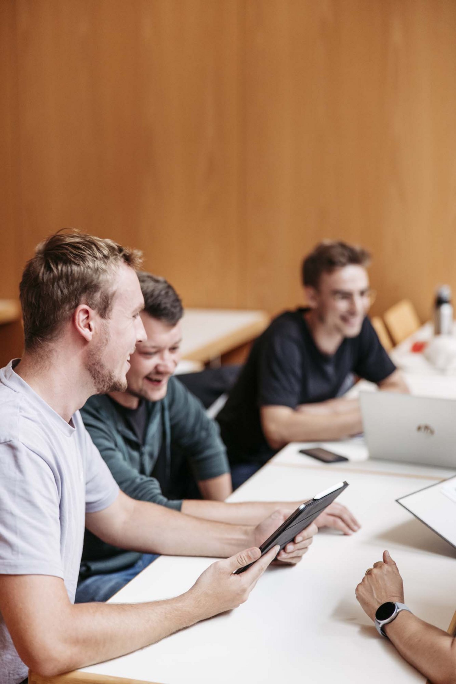 Man sieht zwei Personen zusammen eine Projektarbeit machen.