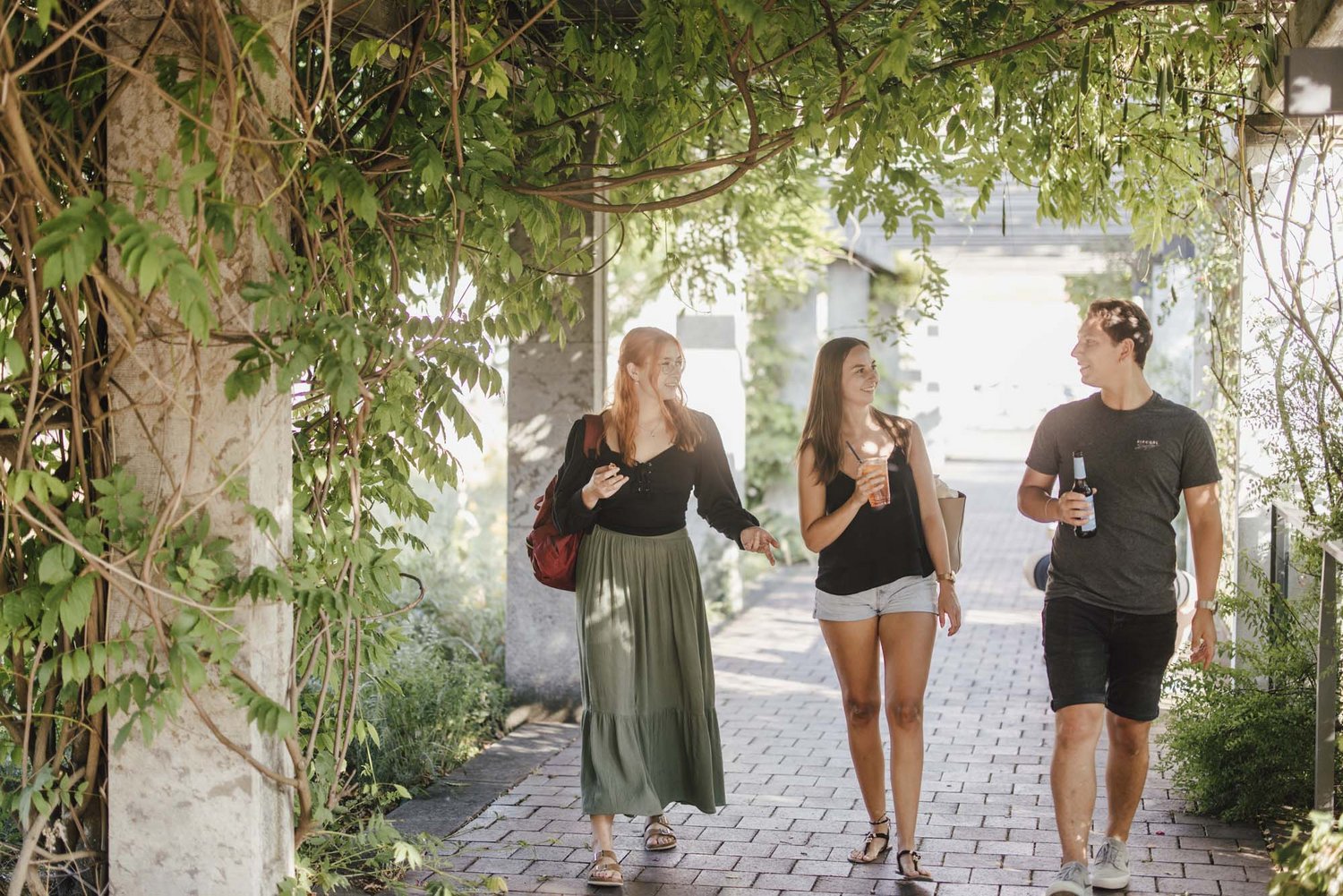 Eine Gruppe geht durch eine begrünte Weg