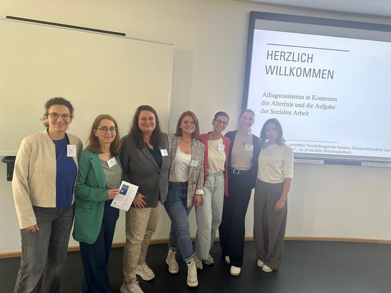 Gruppe von Personen an Vortragenden zum Thema Alltagsrassimus in Kontexten des Alter(n)s und Aufgabe der Sozialen Arbeit