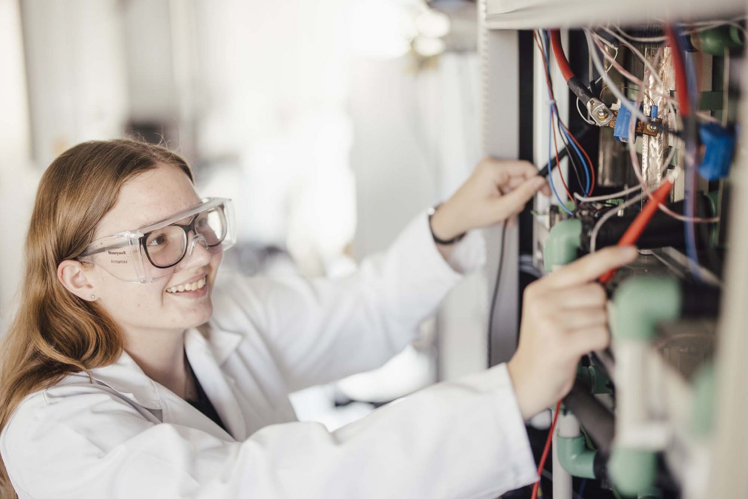 Eine Person hat zwei Materialen in der Hand und lächelt.