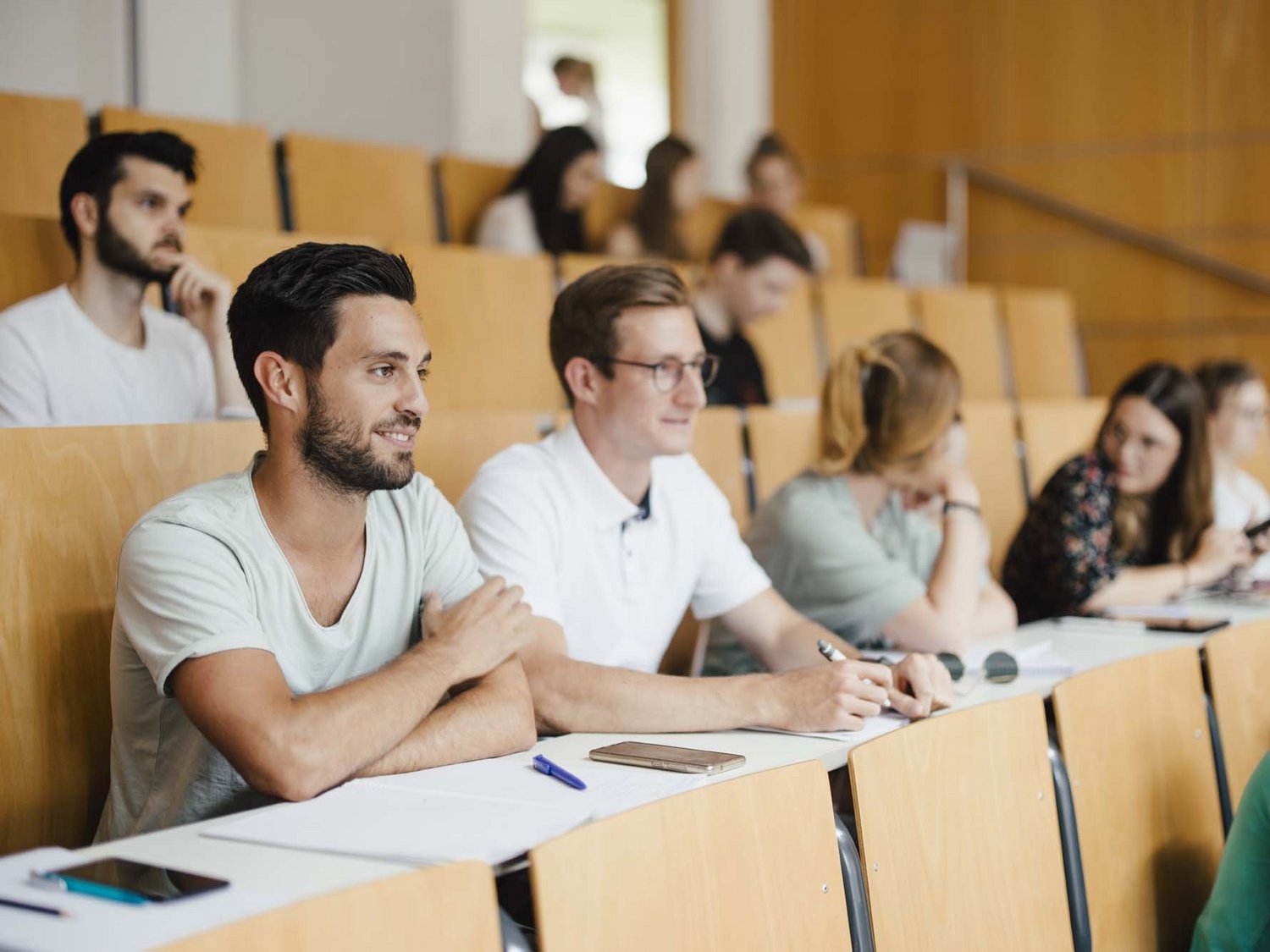 Mehrere Personen sitzen in einem Hörsaal.