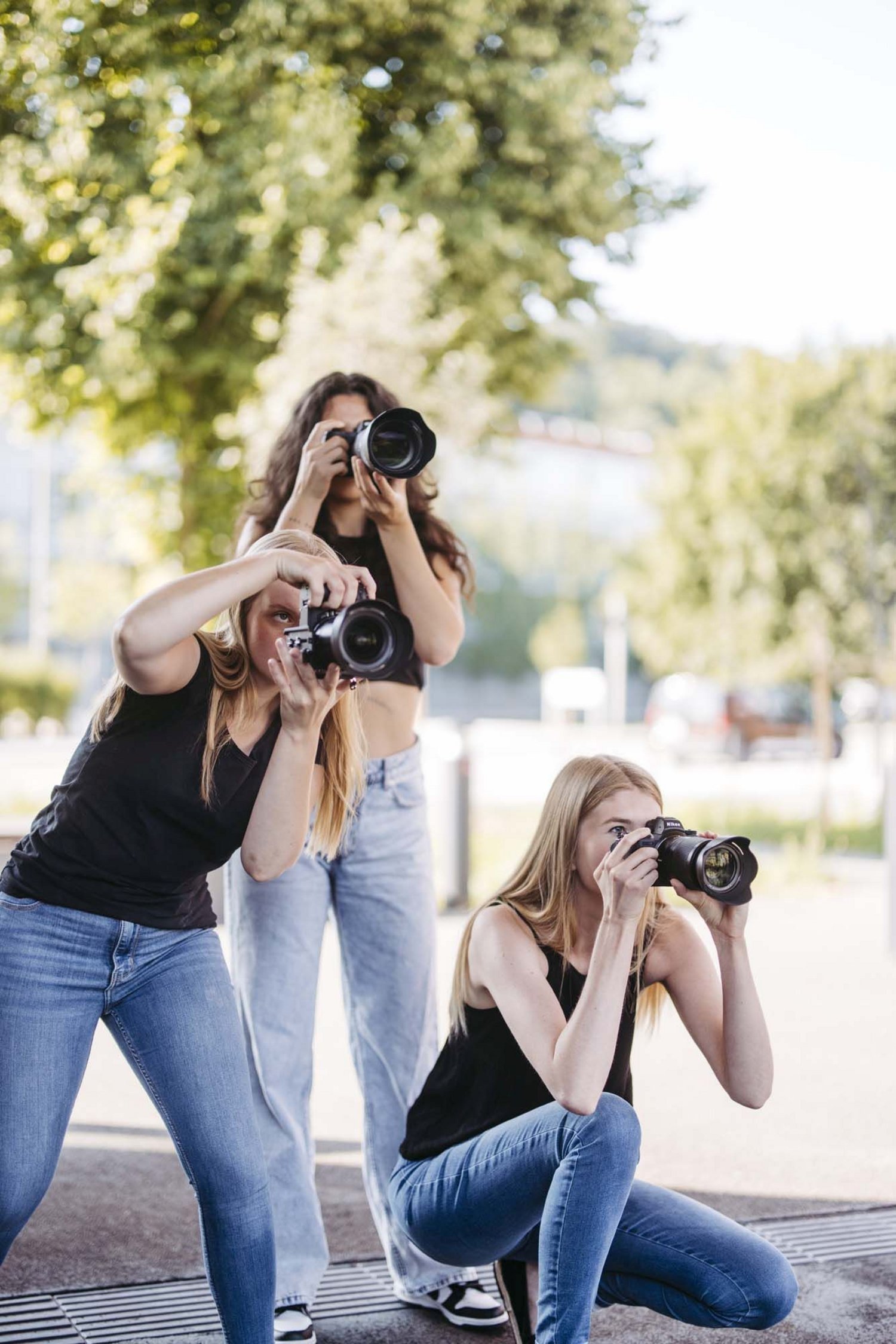 Foto: Drei Studierende mit Kamera auf dem Campusgelände