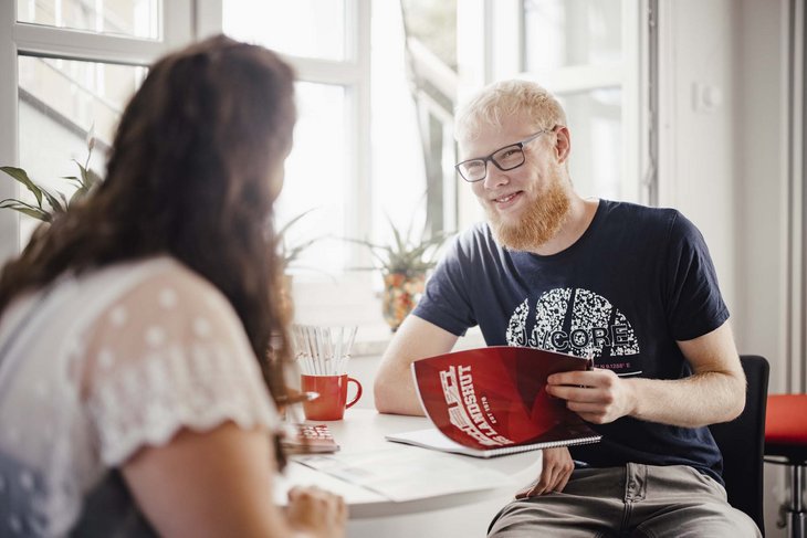 Zwei Personen sitzen gegenüber und schauen sich gegenseitig an.